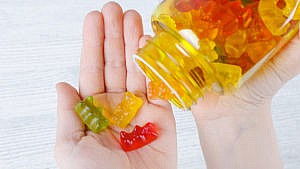 Photo of a adult pouring gummy bear vitamins into their hand