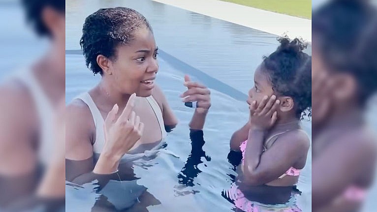 Photo of Gabrielle Union and her daughter Kaavia in a pool, Gabrielle is explaining something and Kaavia has her hands on her face looking shocked
