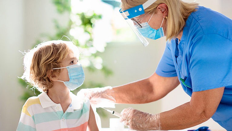 a nurse gives a young boy a vaccine