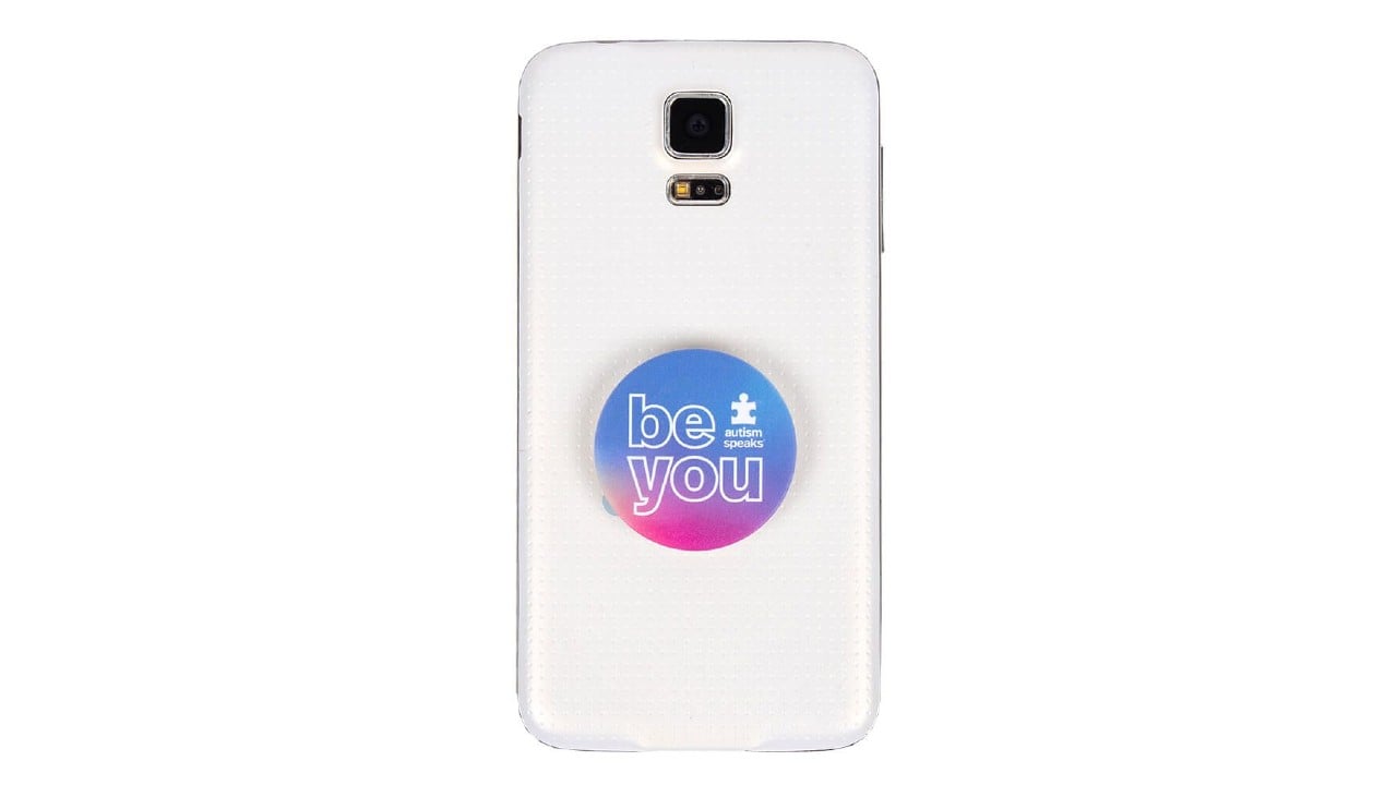 White smart phone with purple and pink pop socket that reads "be you"