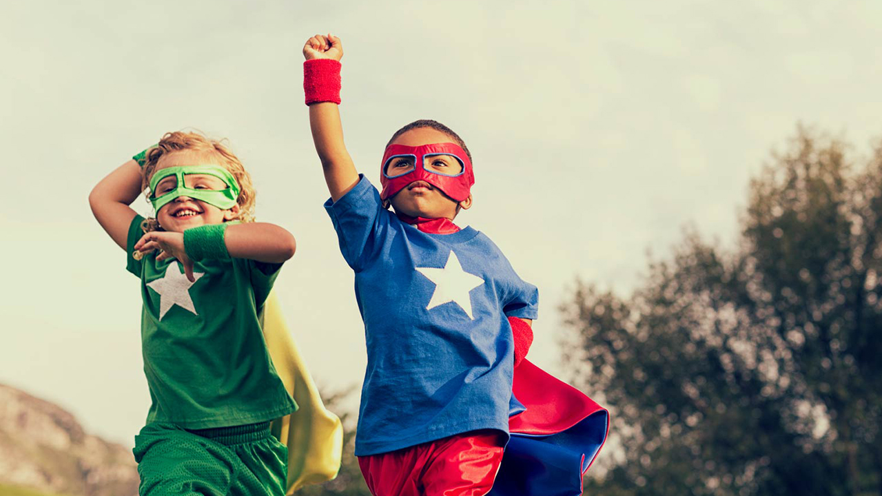 Kids dressed as superheroes running