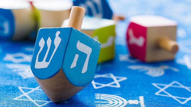 photo of a dreidel on a blue table with more dreidls in the back