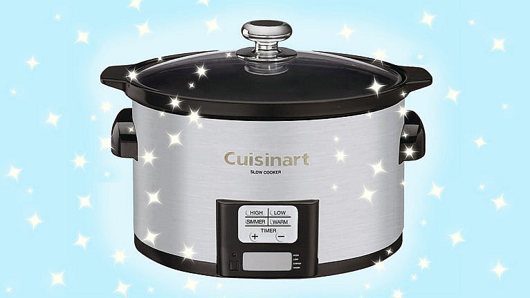 a silver slow cooker in front of a blue background