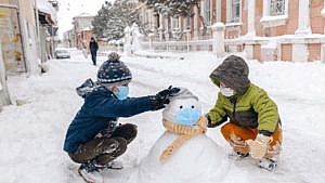 Two kids building a snowman