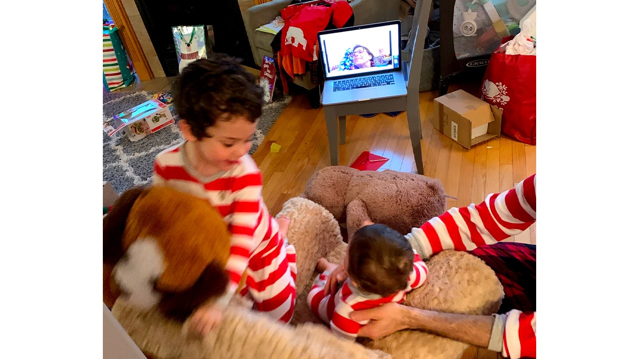 Photo of kids running around on Christmas Day in their pajamas while facetiming with grandparents