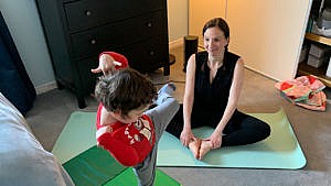 Photo of a mom and her kid doing yoga in their bedroom