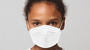 Photo of a young girl wearing a white N95 mask