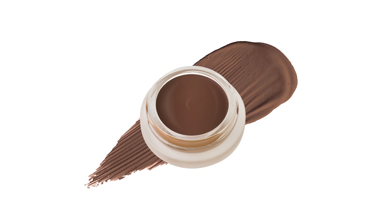 A beige circular container containing concealer.