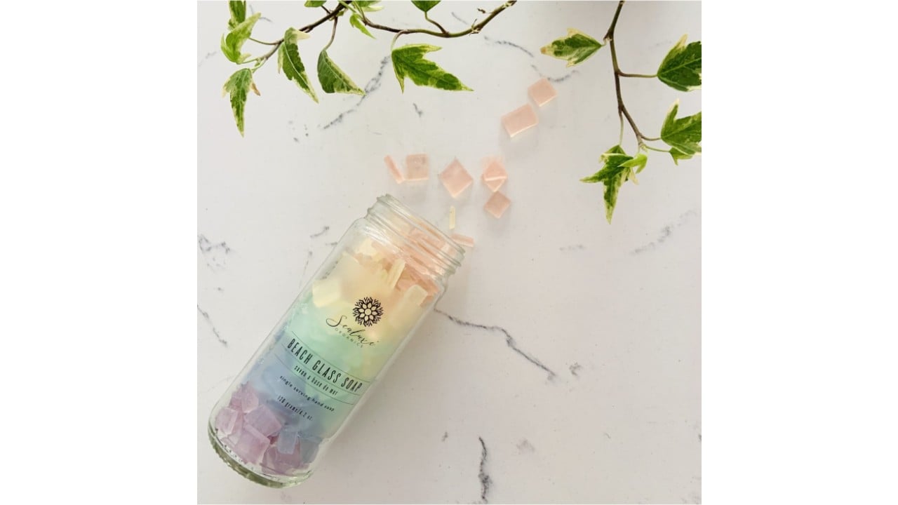 Glass bottle with colourful pieces of soap on a lifestyle background