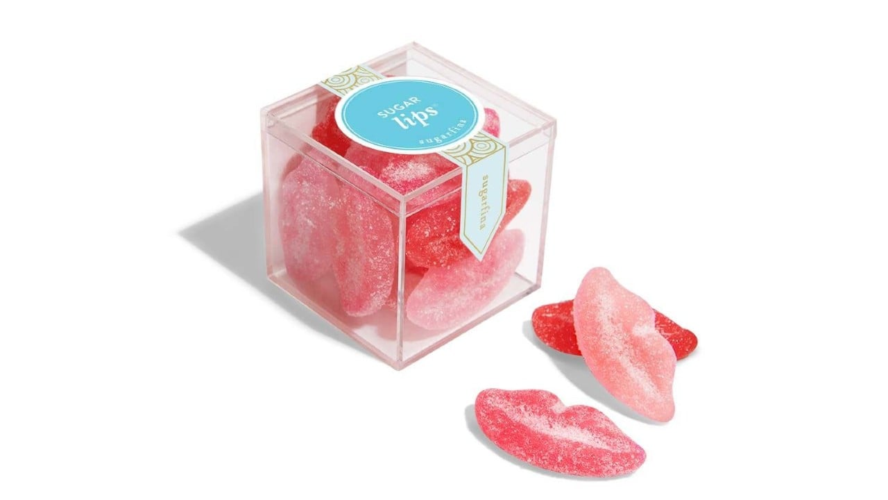 Clear plastic cube with lip-shaped candies
