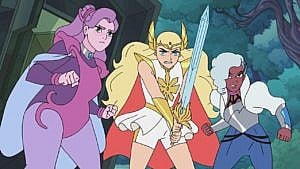 An image of the cartoon She-Ra and the Princesses of Power; one character is purple, another is blonde holding a sword, and the third has gray hair, wearing blue.