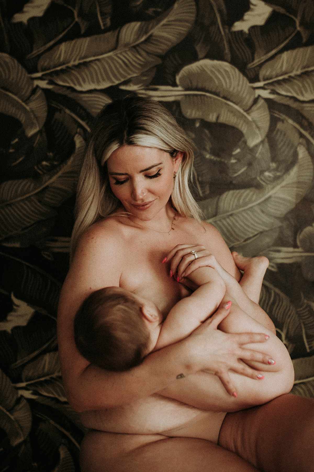 Sarah Nicole Landry a.k.a The Bird's Papaya gazes down lovingly at her baby girl while nursing her