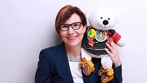 An image of Dr. Cindy Blackstock holding a stuffed white bear.