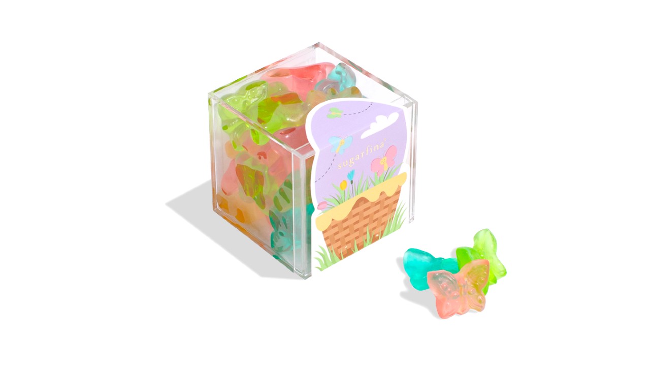 A clear box filled with pink, green and blue gummy butterflies.