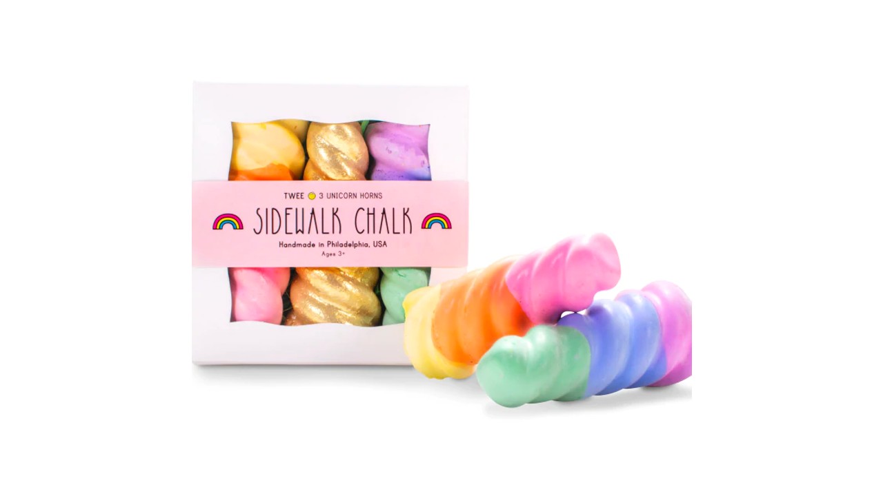 A box of sidewalk chalk that looks like unicorn horns. The chalk is multicoloured and gold