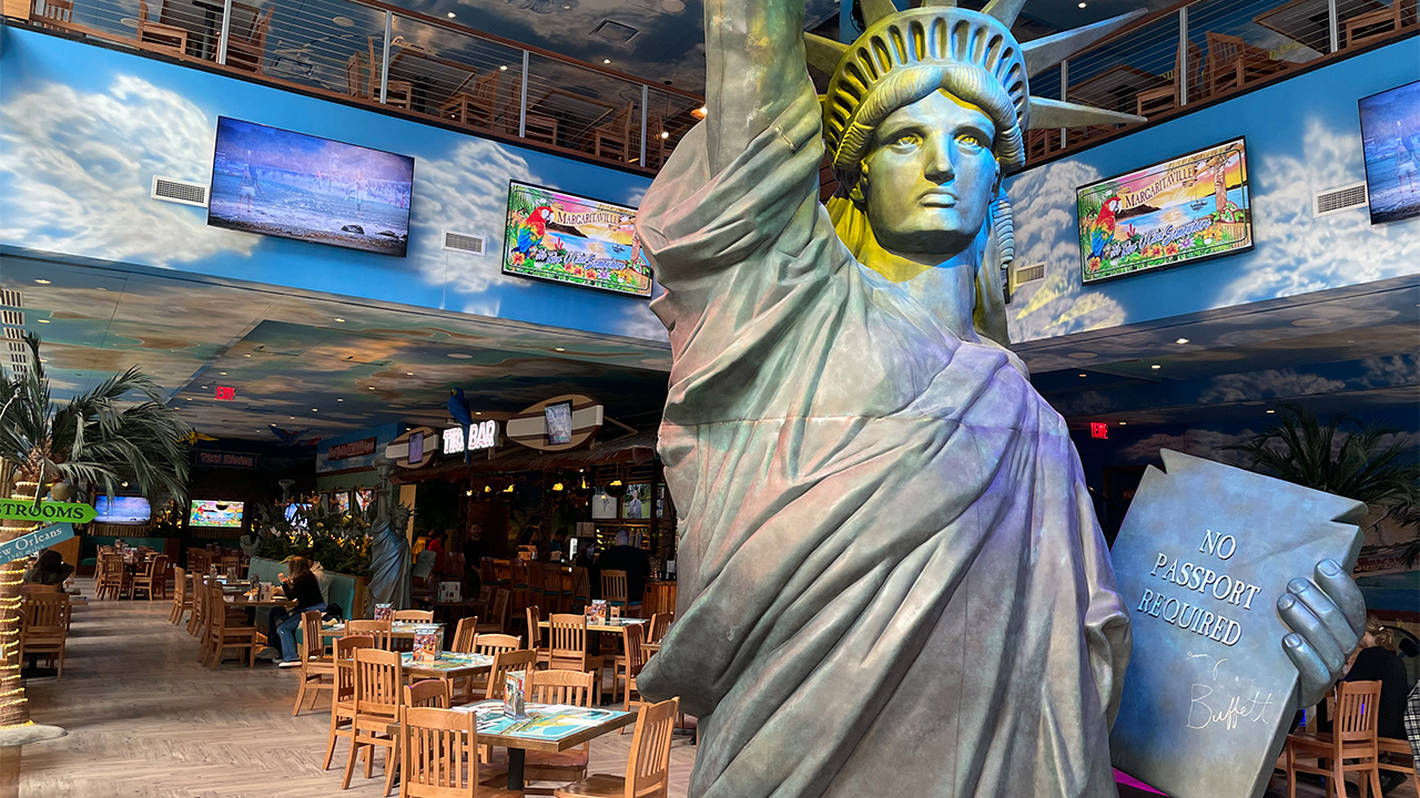 The interior of Margaritaville in New York City with a giant Statue of Liberty right in the middle of the dining area.