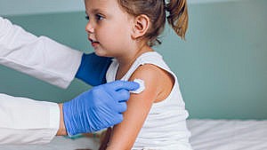 A little girl under the age of five receiving her covid vaccine.