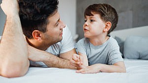 A father and son having a conversation. The father explains transgender to a child