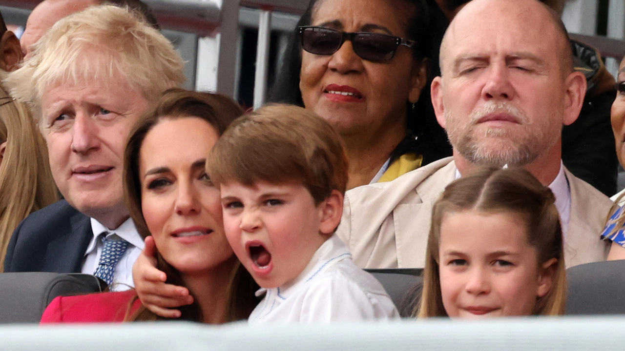 Prince Louis makes an excited face as he holds Kate's neck during the platinum anniversary pageant