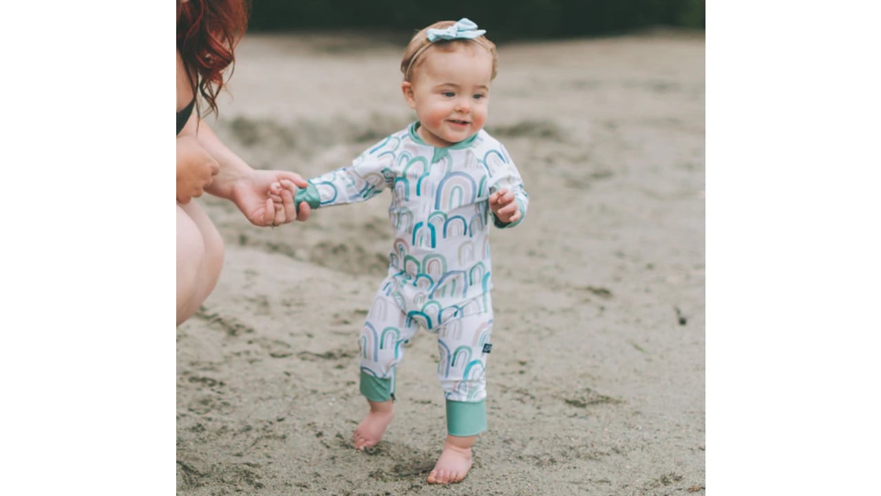 Toddler wearing a one-piece tan, cobalt blue, mint green and cream sunsuit