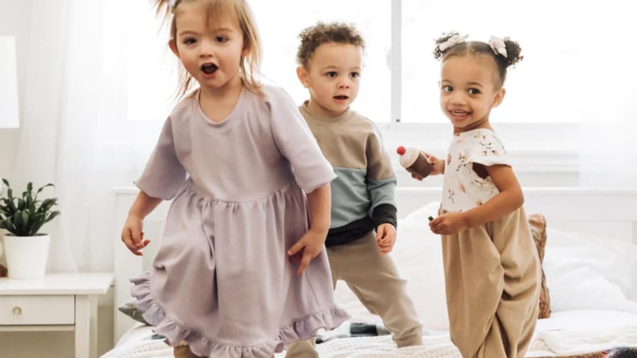 Three children modeling gender-neutral clothing from Five Little Wildlings