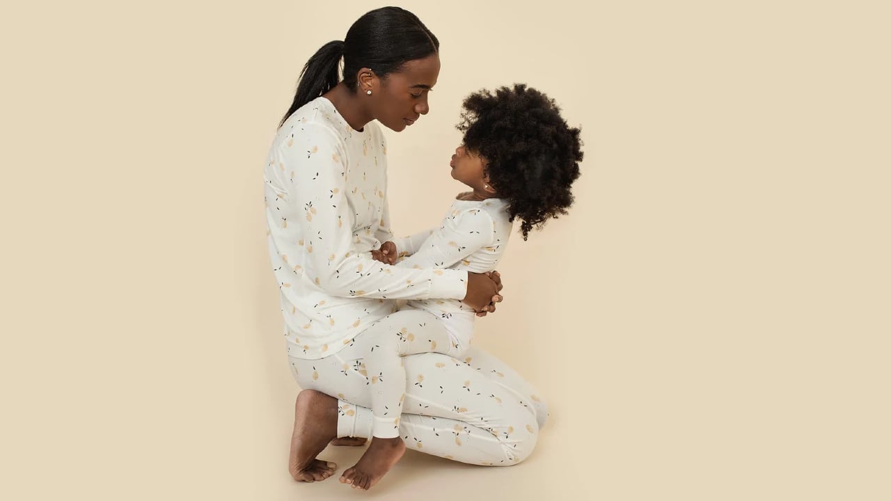 A mother and child wearing matching gender-neutral sleepwear from Petit Lemme