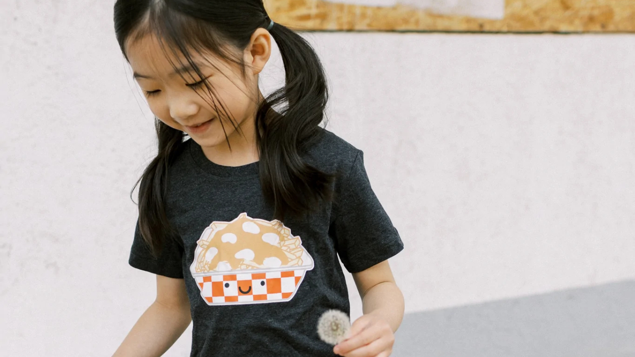 A girl wears a gender-neutral poutine t-shirt from Whistle & Flute