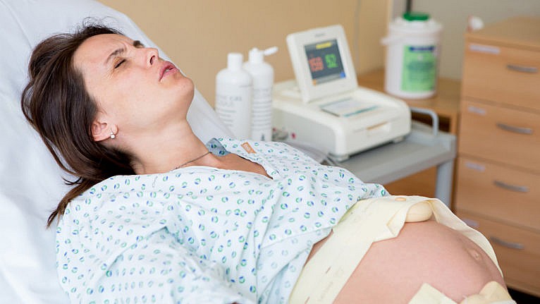 a woman breaths through a contraction while in labour in the hospital