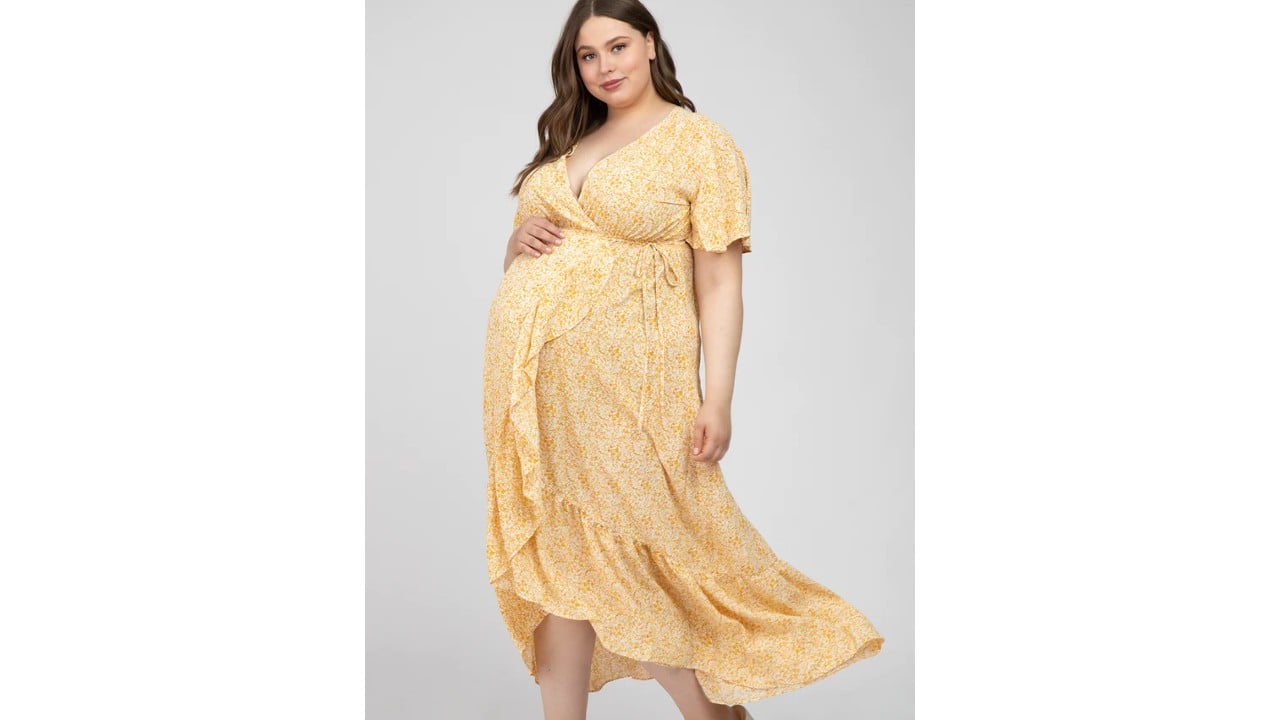 Pregnant woman wearing a yellow floral print maternity midi dress