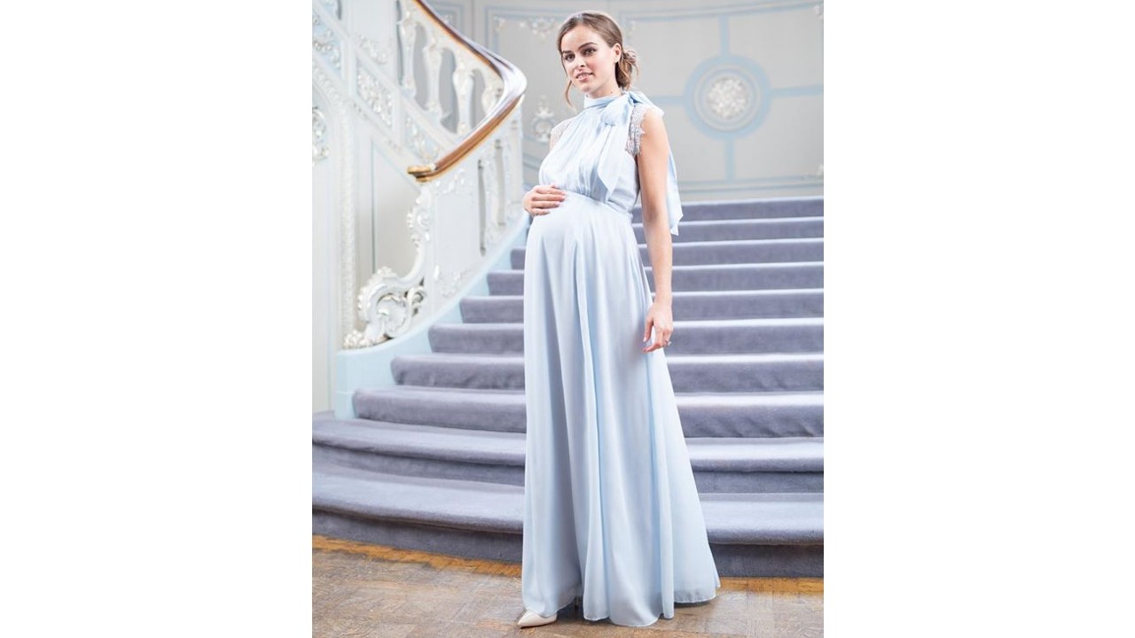 Pregnant woman wearing formal baby blue maternity dress