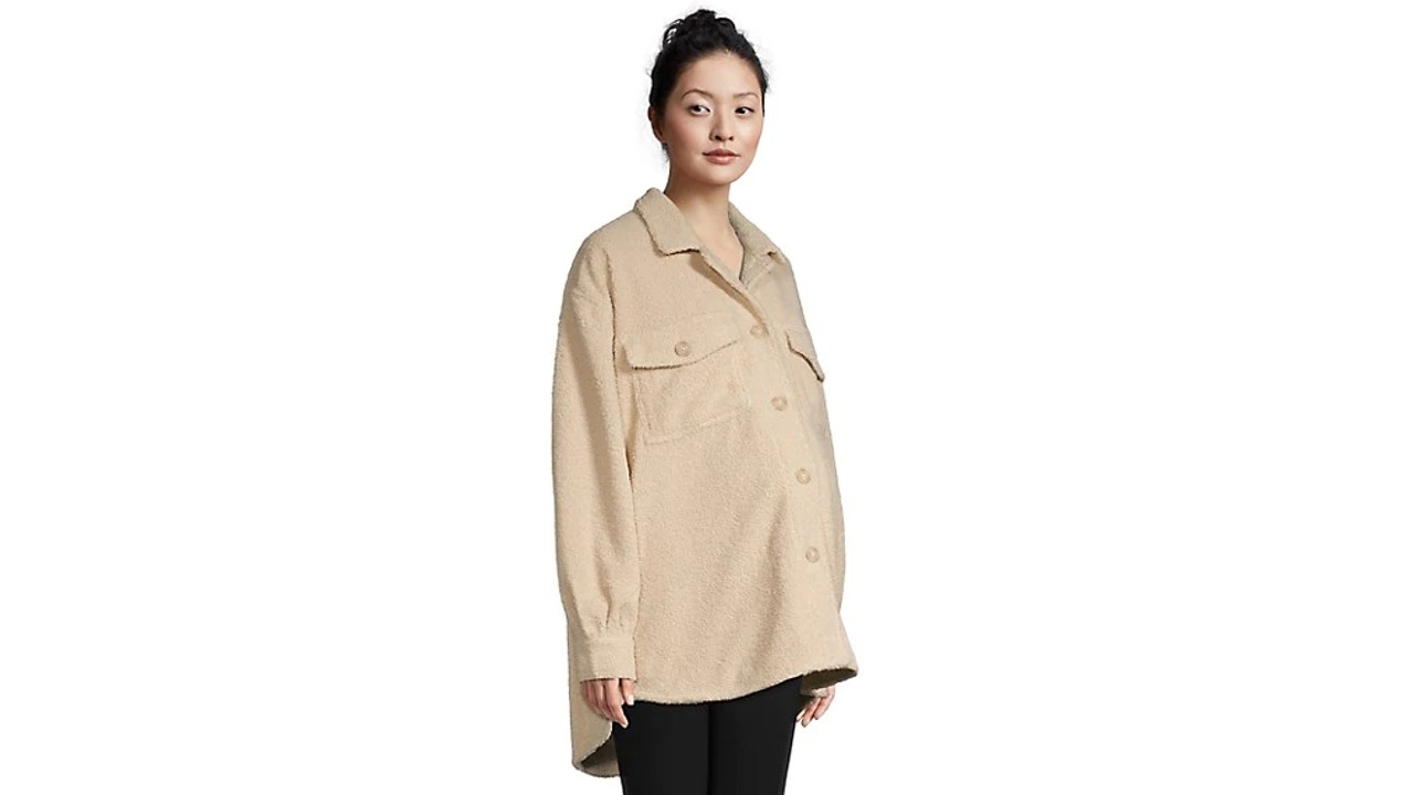 Pregnant woman wearing a beige maternity fleece shacket with a spread collar, button closure at the front and dual flap pockets.