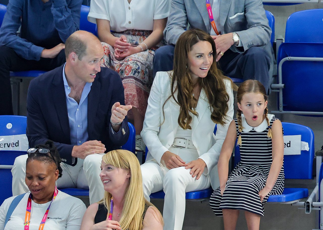 Prinses Charlotte kijkt verbaasd op de tribunes bij de Commonwealth Games met prins William en Kate Middleton.