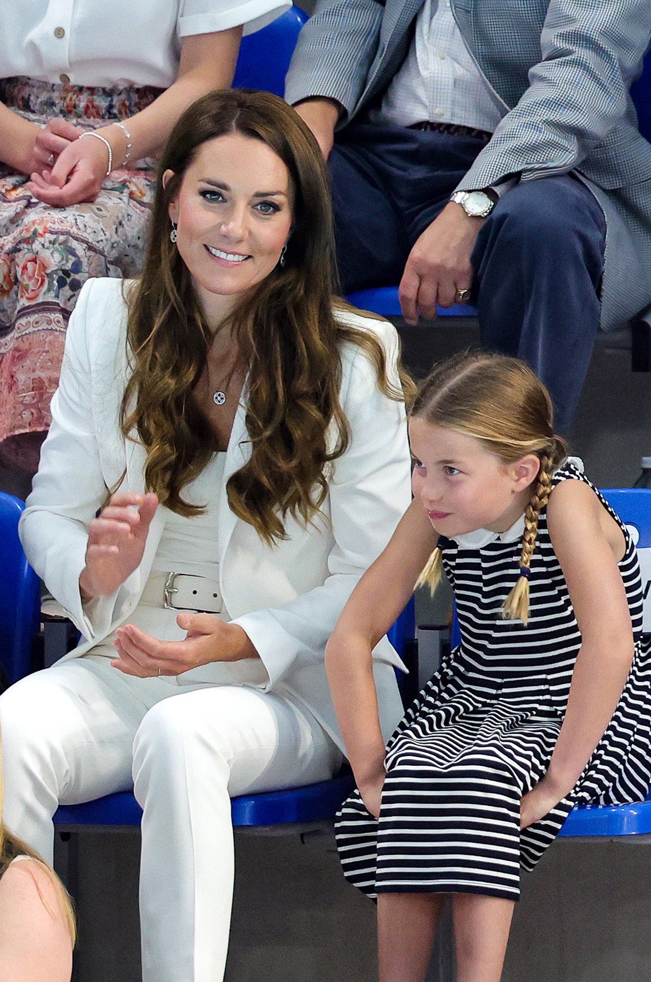 Kate Middleton and Princess Charlotte sit in the stands at a Commonwealth Games swim meet.