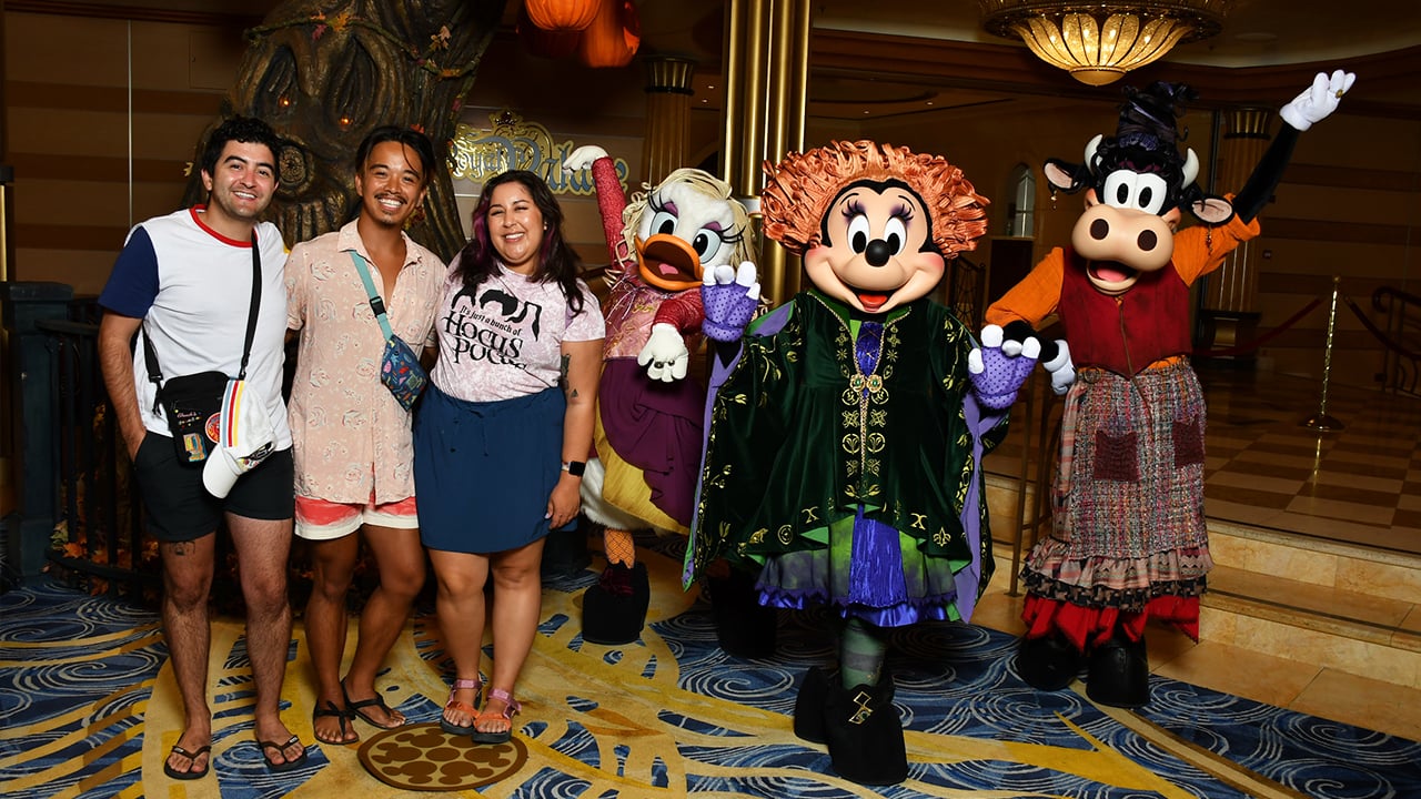 Kevin and his friends take a photo with Minnie, Daisy and Clarabelle Cow dressed in their new costumes as the Sanderson Sisters from Hocus Pocus during the Halloween on the High Seas cruise.