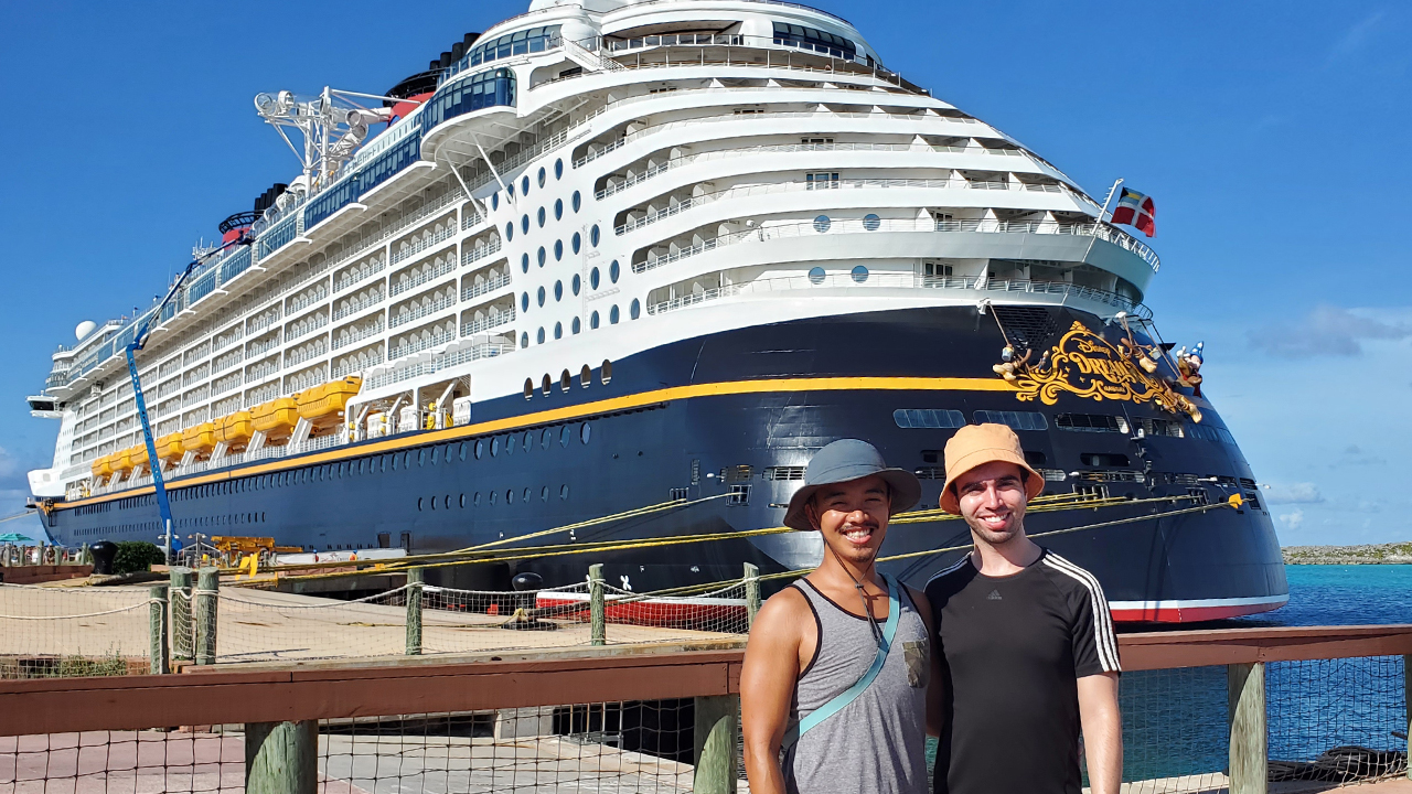 Kevin and his partner take a picture in front of the ship while it docks at Disney's private island Castaway Cay.