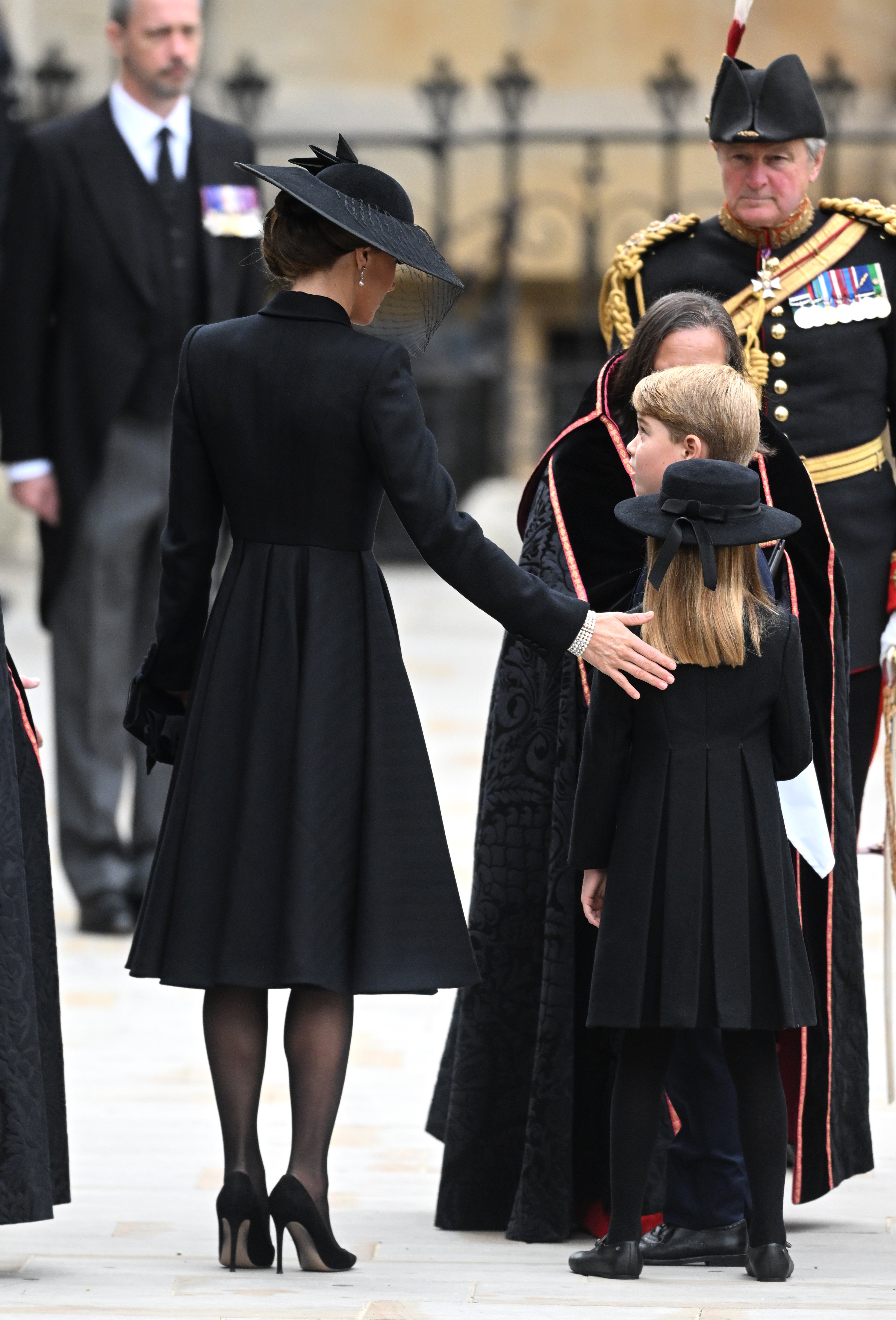 Princezná z Walesu položí ruku na rameno princeznej Charlotte pred pohrebom kráľovnej vo Westminsterskom opátstve.