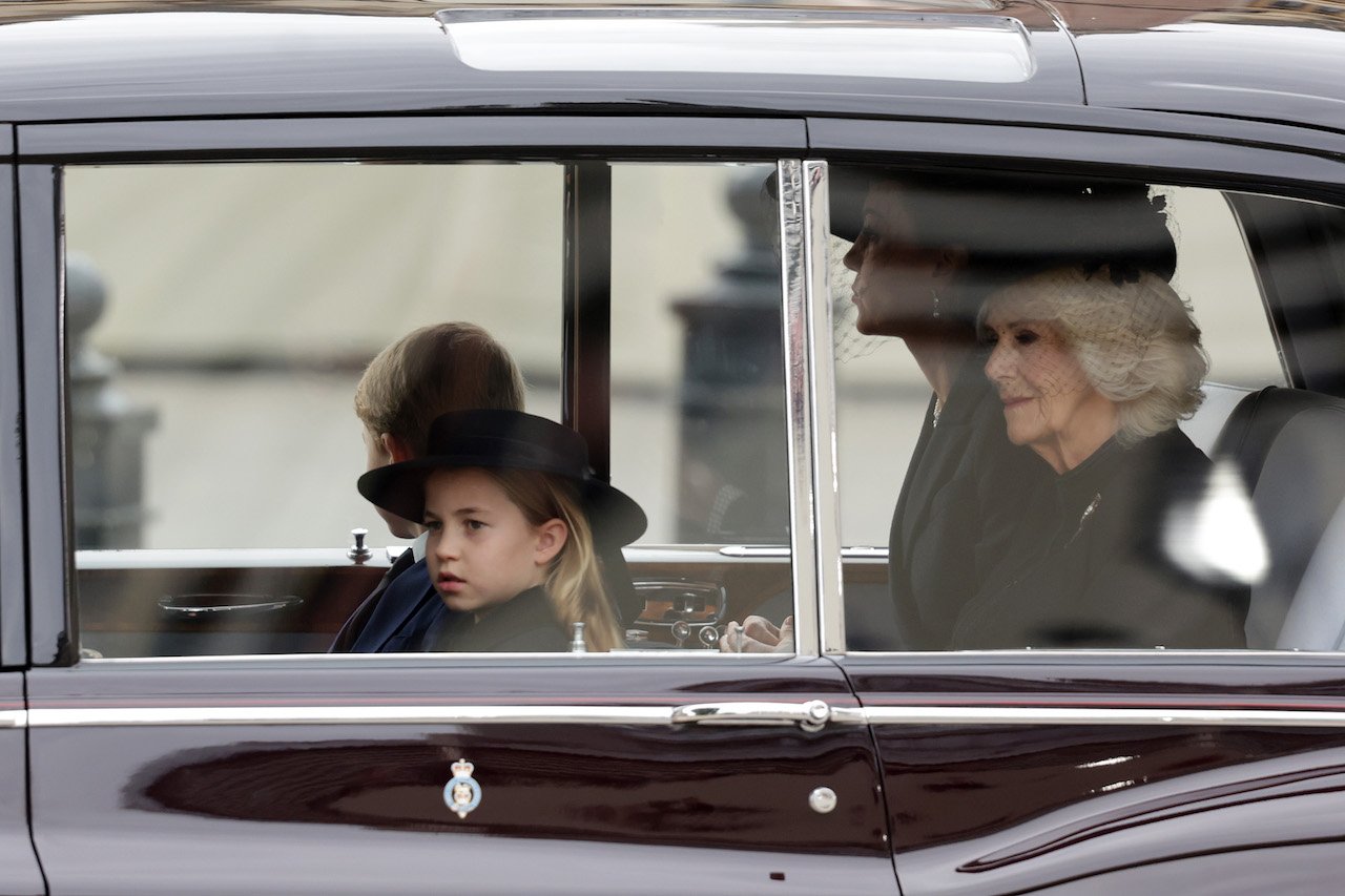 Princezná Charlotte a Queen Consort sú vidieť z okna auta, keď prichádza na pohreb kráľovnej vo Westminsterskom opátstve.