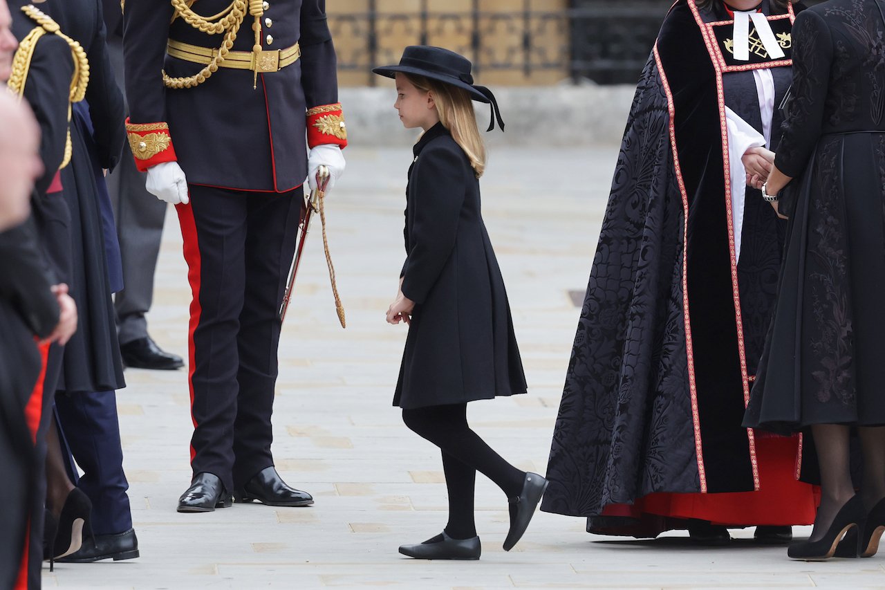 Princezná Charlotte, oblečená celá v čiernom, vstupuje do Westminsterského opátstva na kráľovnin pohreb.