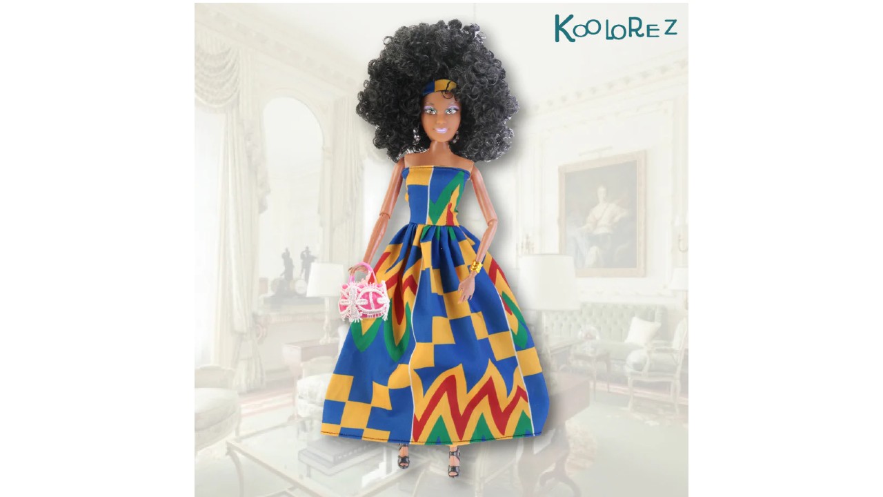 a Black doll with black curly hair and wearing an African-inspired dress