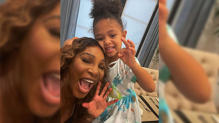 A picture of Serena Williams and her daughter Olympia smiling while doing cute handsigns.