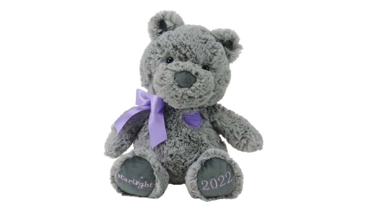 Grey plush bear with purple heart on his chest and a purple bow