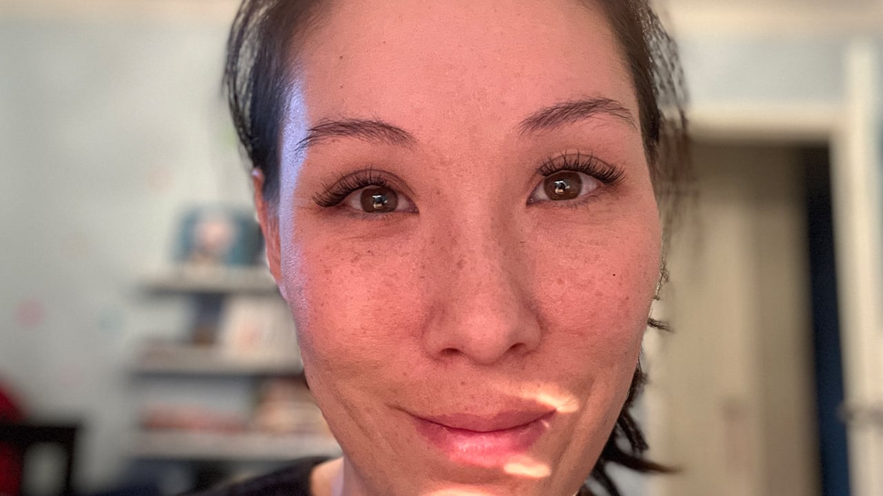 A close-up of a woman's face after getting DIY lash extensions.